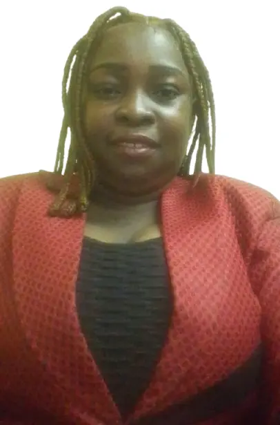 view of a coastal Mediterranean village on a hillside, with small boats in the water.