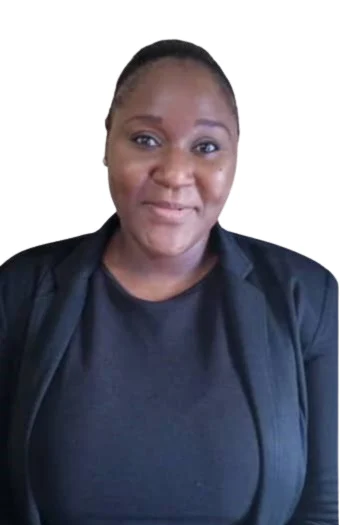 view of a coastal Mediterranean village on a hillside, with small boats in the water.
